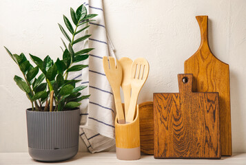 Cutting board,kitchenware,dishtowel and flower on white wall background.Modern kitchen background...