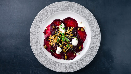 Appetizer of beetroot, pumpkin and sunflower seeds, capers, sour cream and microgreen.