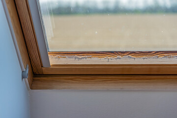 Roof window after leaking, wood is starting to rot, old weathered wooden window