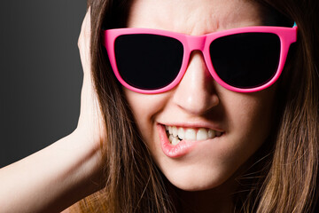 Naklejka premium I like my fashion with a bit of funk. Shot of a young woman wearing sunglasses against a studio background.