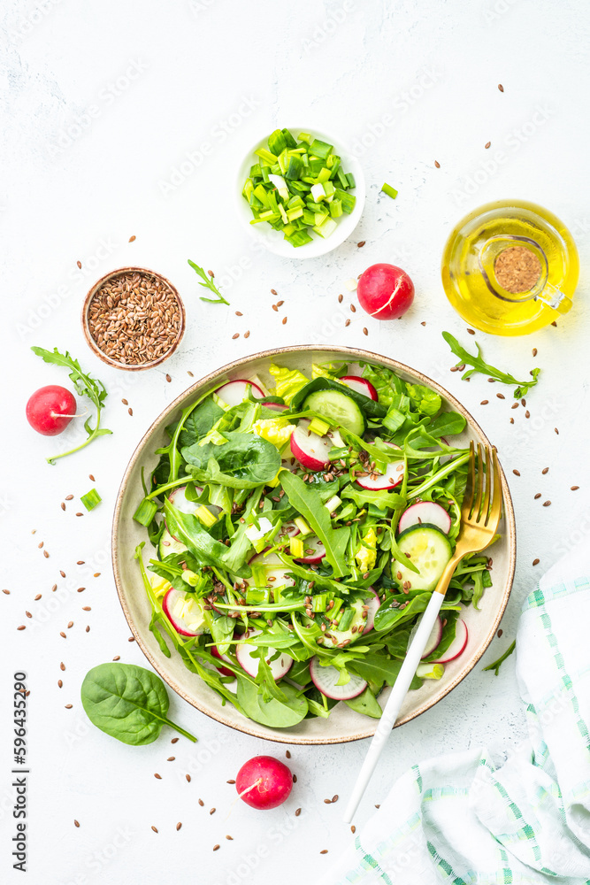 Sticker green salad with spinach, arugula and radish with olive oil on white table. top view with copy space