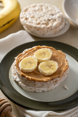 Puffed rice cake with banana and peanut butter, healthy protein snack.