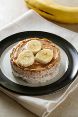 Puffed rice cake with banana and peanut butter, healthy protein snack.
