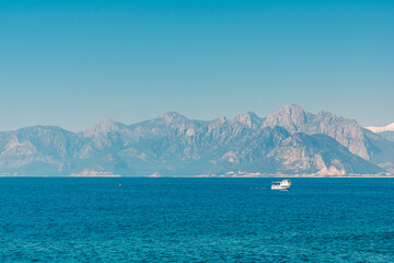 Aerial view of the sea horizon and mountains above it in the Turkish city of Antalya. Yacht in the mediterranean sea against the backdrop of mountains.