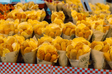 Spicy french fries wrapped in paper cone at the Boqueria market, Barcelona (Spain). High quality photo