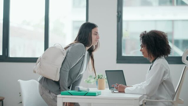Video of beautiful cheerful female doctor talking while explaining medical treatment to patient in the consultation.