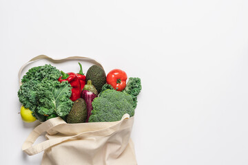 Cotton bag with vegetables and fruits on white background. Zero waste grocery shopping. Sustainable...