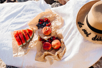 beautiful picnic with fruits on a stone by the sea