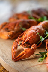 Boiled crayfish with lemon, dill and herbs on a wooden cutting board on blue wooden background. Crayfish dish