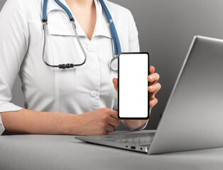 Mobile phone screen mockup, medical mock-up for in doctor hand at work with laptop computer,...