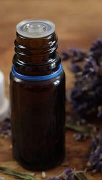 bouquet de lavande s&eacute;ch&eacute;e et Flacons verre d'huile essentielle, en gros plan, sur une table	