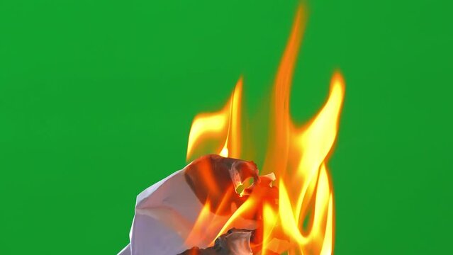 Fire flame burning paper and glowing on green screen background