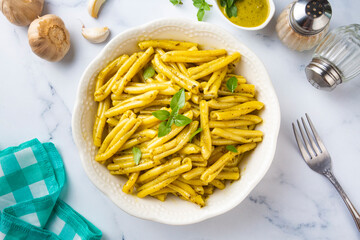 Casarecce pasta with cilantro pesto sauce on a grey background, top view. Delicious vegetarian lunch.