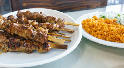 Turkish shish kebabs with bulgur pilaf with tomato paste on table. Middle eastern islamic halal nutrition.