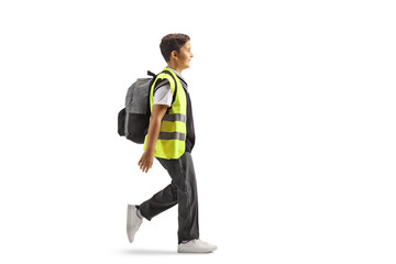 Full length profile shot of a schoolboy wearing a safety vest and walking