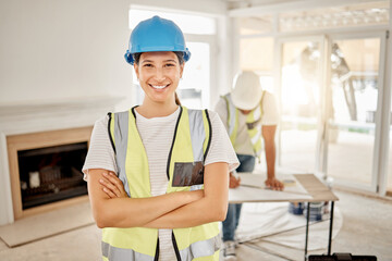 Fototapeta premium Weve designed your perfect home. Shot of an attractive young construction worker standing in a house with her arms folded.