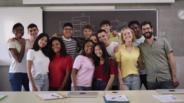 Portrait Of Large Group Of Happy Students Looking At Camera Posing For Photo And Hugging In Class. Multiracial Youngsters Take Photo Together For School Album And Social Media. Back To School. 