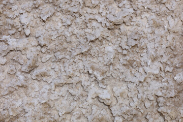 Abstract nature background seashore. Texture of sea salt on the beach. The remains of sea salt frozen in time in the land. Salt lake in the desert. Mining of minerals. Top view.