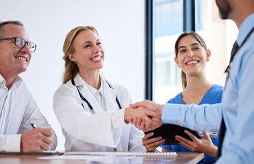 the medical world is bigger than I thought. Shot of two doctors shaking hands in a meeting at a hospital.