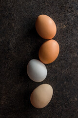 Whole chicken eggs on black table. Top view.