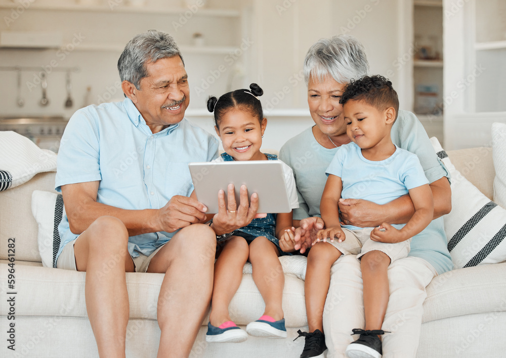 Poster Family is not an important thing. Its everything. Shot of grandparents bonding with their grandchildren and using a digital tablet on a sofa at home.