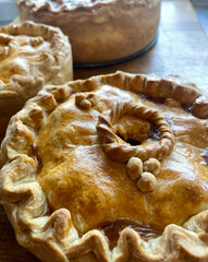 Celebrations of Traditional Pork Pie on a wooden kitchen table © Cookandphotoshoot