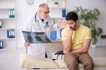 Obraz premium Young male patient visiting old male doctor radiologist