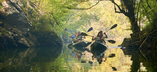 A group of friends enjoying having fun and kayaking while exploring the calm river, surrounding forest and large natural river canyons