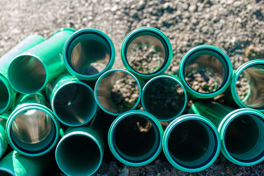 stack of green sewer pipes for laying sewerage on a constructioon site