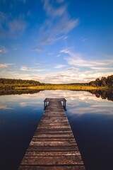 Fototapeta premium Beautiful summer afternoon landscape by the lake. Charming wooden pier over a small lake in Michala Gora, Poland.