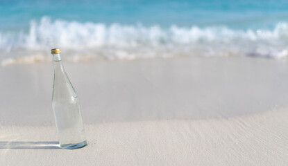 Glass bottle of pure water on the background of ocean