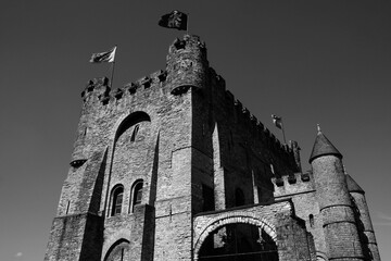 Die Burg Gravensteen der Grafen von Flandern mit altem Mauerwerk und Zinnen aus dem Mittelalter in der Altstadt von Gent in Ostflandern in Belgien in neorealistischem Schwarzweiß