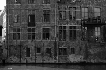 Altes saniertes Lagerhaus und Backsteinbau am der Leie und der Grasbrug in der Altstadt von Gent in Ostflandern in Belgien in neorealistischem Schwarzweiß