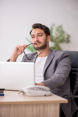 Naklejka premium Young male employee working in the office