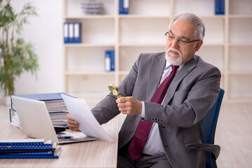 Old male employee working in the office