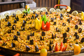 Big seafood paella with vegetables, fruits and mussels
