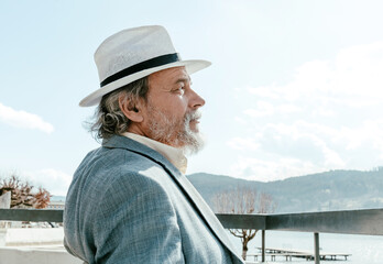 Obraz premium Portrait of a confident, handsome, mature man, pensioner, grandfather in the small town