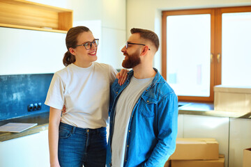 Hugging couple celebrating moving Into new home.