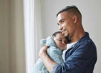 This is the best feeling. Shot of a young father embracing his baby at home. - Powered by Adobe