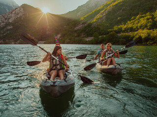 A group of friends enjoying fun and kayaking exploring the calm river, surrounding forest and large natural river canyons during an idyllic sunset. - obrazy, fototapety, plakaty