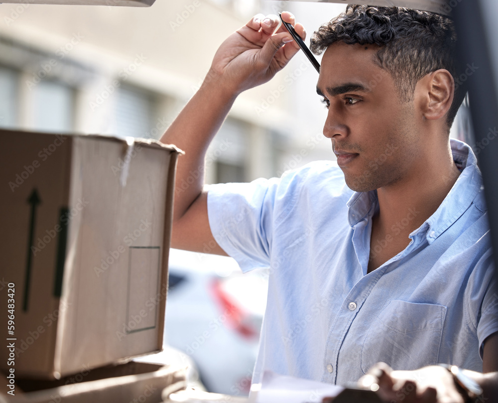 Poster am i missing a box. shot of a young delivery man checking boxes in a van.