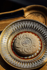 close up of maamoul (ma'amoul), date-filled butter cookies on ornate patterned gold and white plate