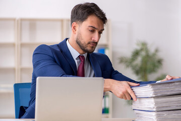 Young male employee sitting at workplace