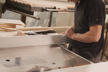 Carpenter with shelves of woodworking machinery