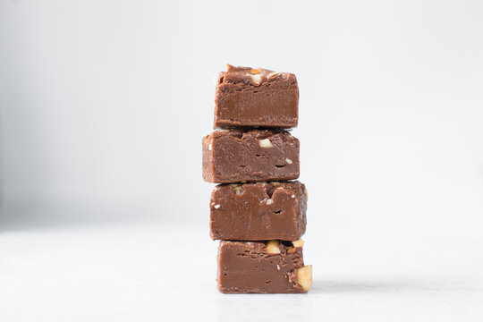 chocolate fudge with nuts on a marble tray, chocolate fudge cut into pieces, fudge candy on a marble tray