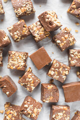 Top view of chocolate fudge with nuts on a marble board, chocolate fudge cut into pieces, fudge candy on a chopping board