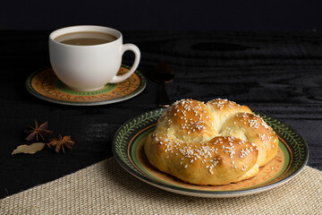 Breakfast at the bakery, afternoon snack, with bread and a cup of coffee. Delicious. Photo with black and blurred background.