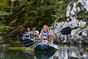 A group of friends enjoying having fun and kayaking while exploring the calm river, surrounding forest and large natural river canyons