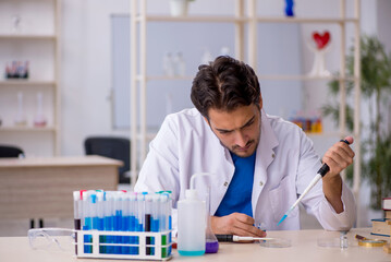 Young male chemist working at the lab