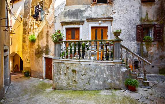 Lovran, Istria, Croatia. Vintage medieval buildings and houses at narrow lanes of old town. Stone stairs, wooden doors windows. Decorative arch between brick walls